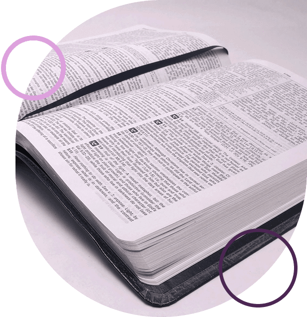 A close up of an open bible on top of a table.